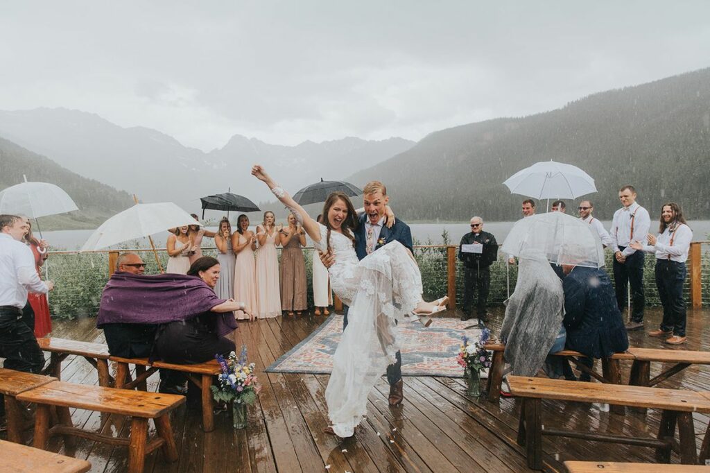 Photo couple souriant sous la pluie lors de la fin de cérémonie